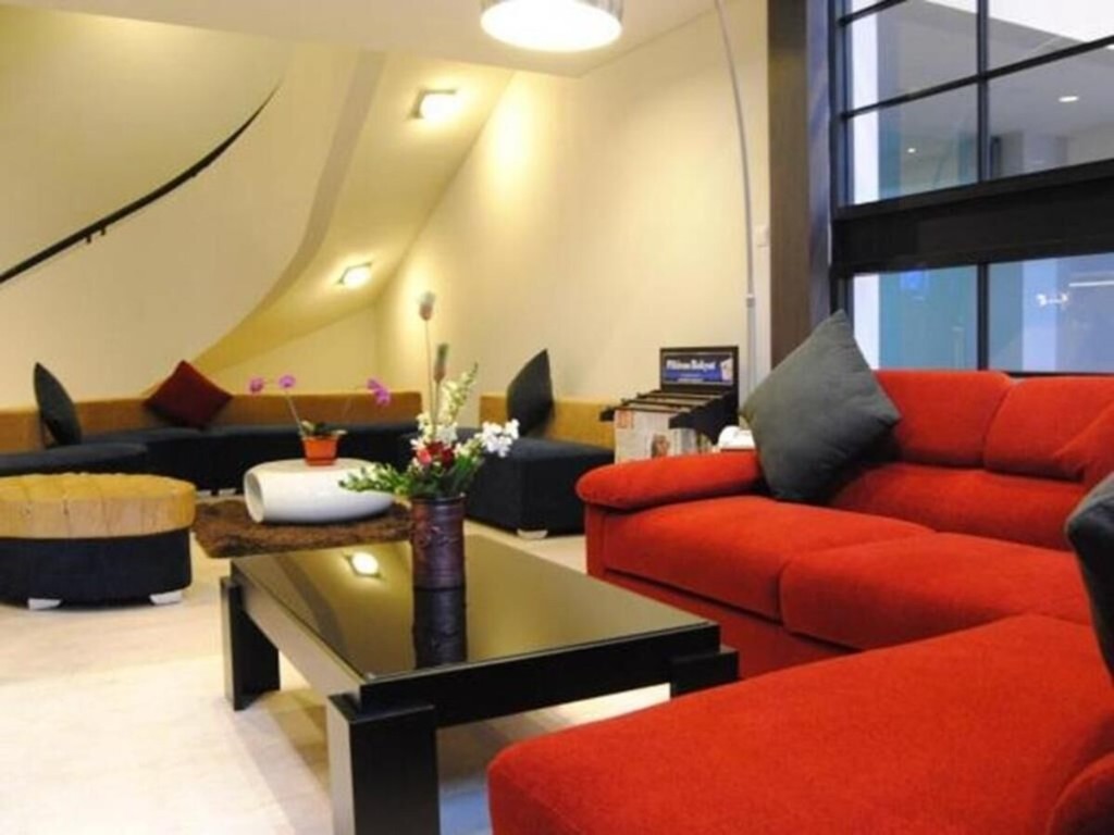Suasana lounge dBest Hotel Bandung dengan sofa merah